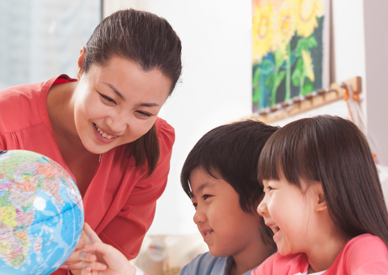 teacher showing students world map in classroom